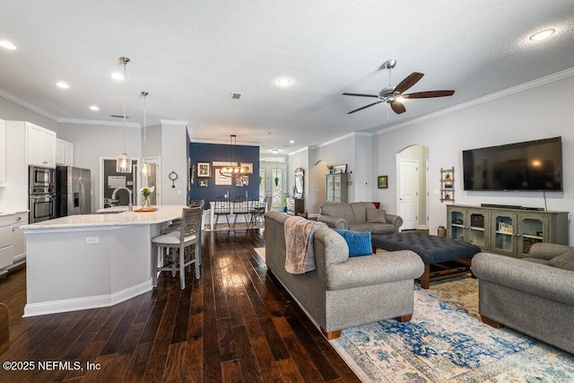2035 Arden Forest Pl, Fleming Island, FL 32003 - living room featuring dark wood-style floors, ornamental molding, a ceiling fan, arched walkways, and recessed lighting