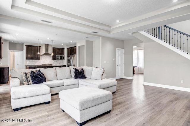 23 Catesby Ln, Saint Augustine, FL 32095 - living area featuring a tray ceiling, recessed lighting, light wood-style flooring, baseboards, and radiator
