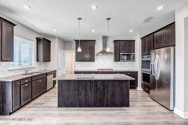 23 Catesby Ln, Saint Augustine, FL 32095 - kitchen featuring stainless steel appliances, wall chimney exhaust hood, a sink, a kitchen island, and dark brown cabinetry
