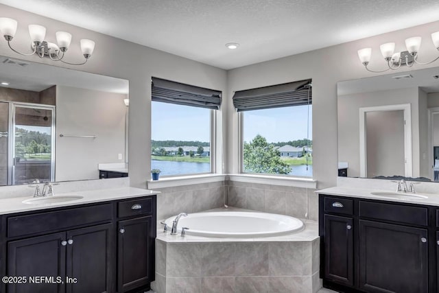 23 Catesby Ln, Saint Augustine, FL 32095 - bathroom featuring a stall shower, a bath, two vanities, and plenty of natural light