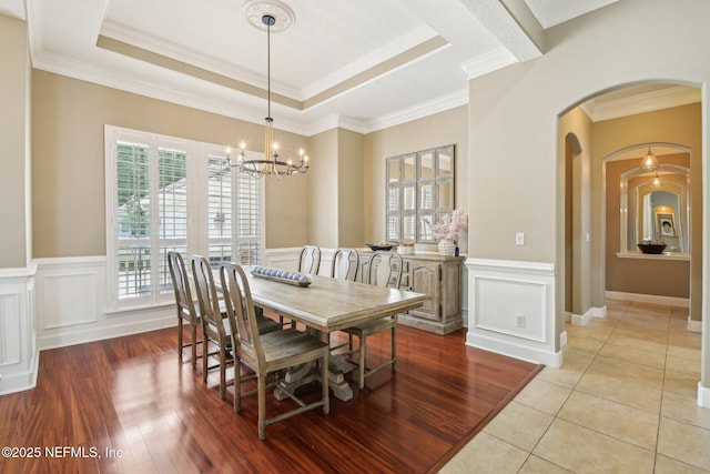 1867 Paradise Moorings Blvd, Middleburg, FL 32068 - dining room with a chandelier, arched walkways, ornamental molding, a wainscoted wall, and a tray ceiling