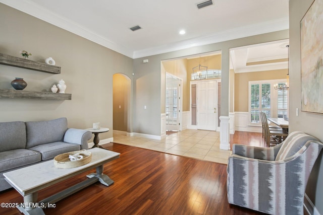 1867 Paradise Moorings Blvd, Middleburg, FL 32068 - living room with arched walkways, crown molding, a chandelier, and wood finished floors
