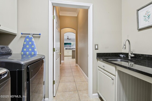 1867 Paradise Moorings Blvd, Middleburg, FL 32068 - washroom featuring cabinet space, crown molding, washer and dryer, light tile patterned flooring, and baseboards
