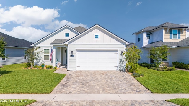 103 Tarbert Ln, Saint Augustine, FL 32092 - view of front of house with board and batten siding, decorative driveway, a front lawn, and an attached garage