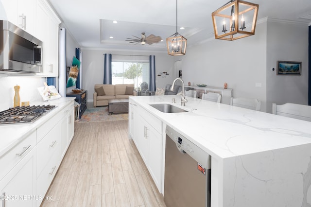 103 Tarbert Ln, Saint Augustine, FL 32092 - kitchen with a sink, appliances with stainless steel finishes, a center island with sink, white cabinetry, and a chandelier