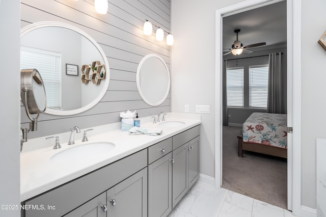 103 Tarbert Ln, Saint Augustine, FL 32092 - ensuite bathroom with double vanity, marble finish floors, a ceiling fan, wood walls, and baseboards