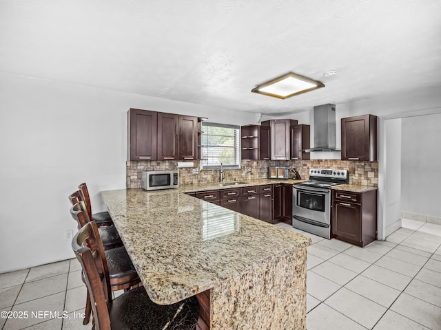 10811 High Ridge Rd, Jacksonville, FL 32225 - kitchen featuring appliances with stainless steel finishes, wall chimney exhaust hood, decorative backsplash, a kitchen bar, and a peninsula