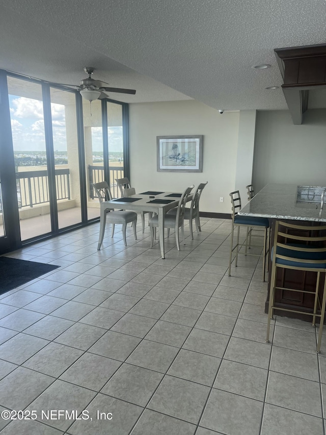 1513 Ocean Shore Blvd Unit 4B, Ormond Beach, FL 32176 - dining area featuring a textured ceiling, a ceiling fan, light tile patterned flooring, and baseboards
