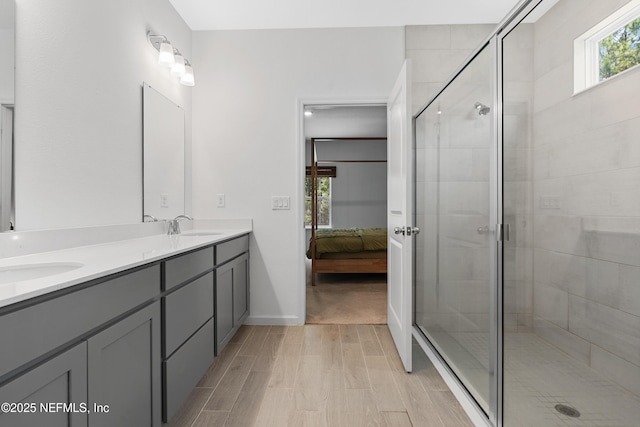 727 Lake Sinclair St, Saint Augustine, FL 32084 - ensuite bathroom featuring wood finished floors, a shower stall, double vanity, and baseboards