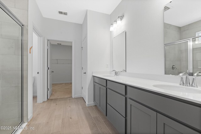 727 Lake Sinclair St, Saint Augustine, FL 32084 - bathroom with a shower stall, wood finished floors, double vanity, and a spacious closet