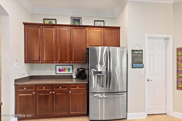 2005 Rivers Own Rd, Saint Augustine, FL 32092 - kitchen featuring stainless steel fridge, dark countertops, arched walkways, ornamental molding, and baseboards