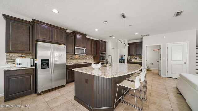 514 Heron Landing Rd, Saint Johns, FL 32259 - kitchen featuring stainless steel appliances, tasteful backsplash, light tile patterned flooring, dark brown cabinetry, and recessed lighting