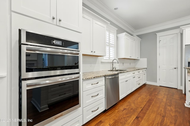 318 Sophia Ter, Saint Augustine, FL 32095 - kitchen with appliances with stainless steel finishes, a sink, crown molding, white cabinetry, and backsplash