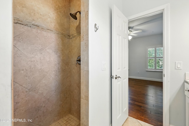 318 Sophia Ter, Saint Augustine, FL 32095 - bathroom featuring tiled shower, wood finished floors, a ceiling fan, baseboards, and vanity