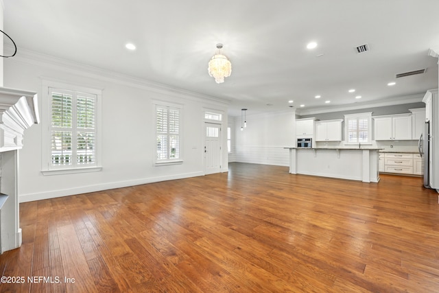 318 Sophia Ter, Saint Augustine, FL 32095 - unfurnished living room featuring crown molding, hardwood / wood-style floors, recessed lighting, a chandelier, and baseboards