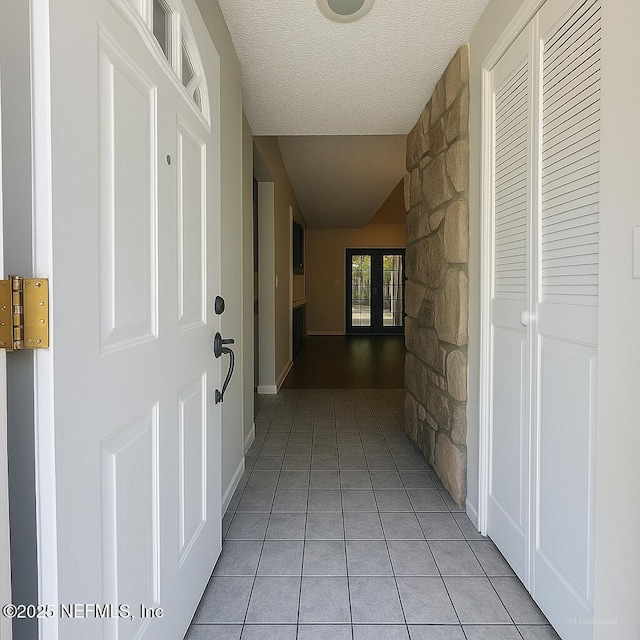 10244 Pine Breeze Rd W, Jacksonville, FL 32257 - corridor featuring light tile patterned flooring, a textured ceiling, and vaulted ceiling