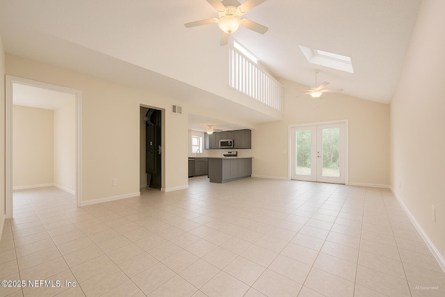 10244 Pine Breeze Rd W, Jacksonville, FL 32257 - unfurnished living room with a ceiling fan, light tile patterned flooring, a skylight, high vaulted ceiling, and french doors