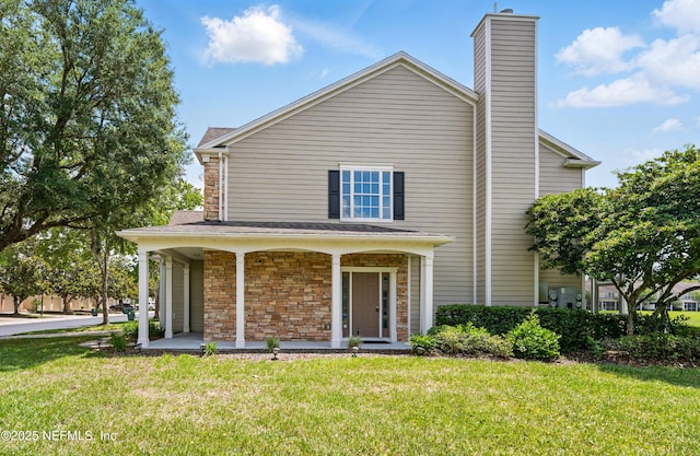 11000 Castlemain Cir E, Jacksonville, FL 32256 - rear view of property featuring covered porch, stone siding, a chimney, and a yard
