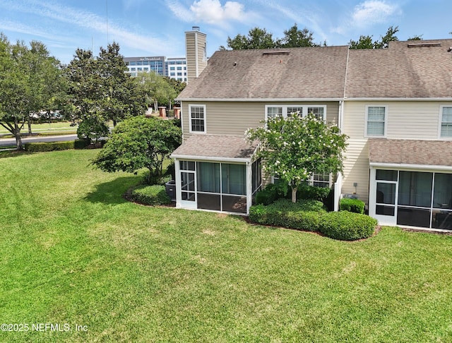 11000 Castlemain Cir E, Jacksonville, FL 32256 - back of property with a sunroom, a lawn, and a chimney