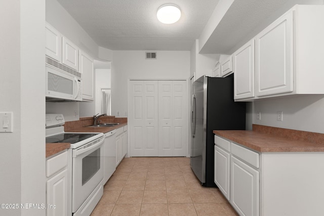 204 Augusta Cir, Saint Augustine, FL 32086 - kitchen with white appliances, white cabinets, light tile patterned floors, a textured ceiling, and a sink