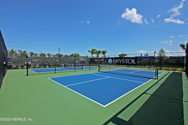 view of tennis court featuring fence and community basketball court