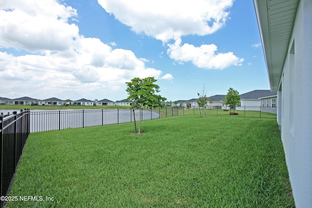 view of yard with a residential view and a water view