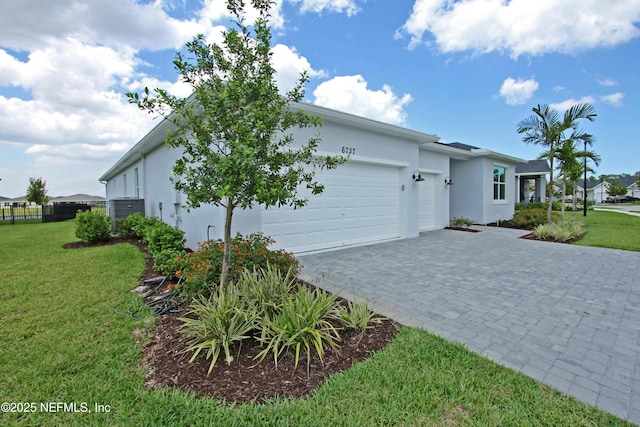 view of front of property with stucco siding, a garage, decorative driveway, and a front lawn