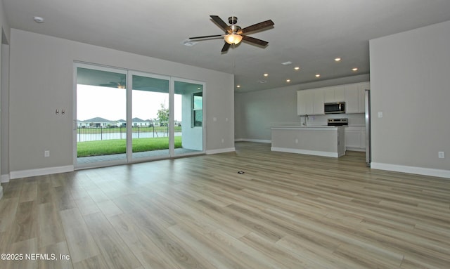 unfurnished living room featuring ceiling fan, baseboards, light wood finished floors, and recessed lighting