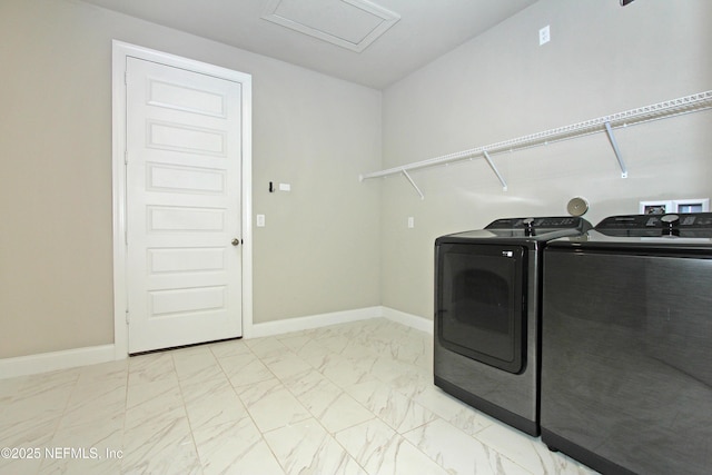 laundry room featuring washer and dryer, light marble finish floors, baseboards, and attic access