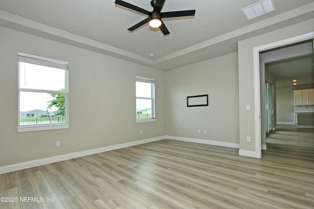 unfurnished room with ceiling fan, light wood-style flooring, and baseboards
