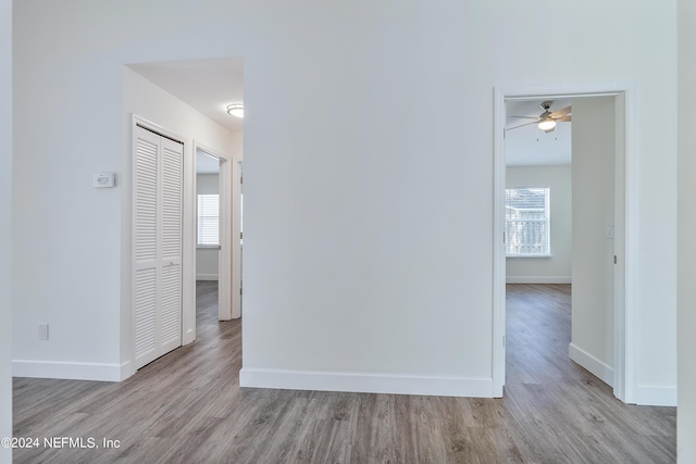 hallway with wood finished floors and baseboards