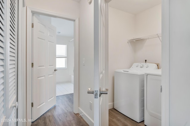 laundry area featuring washer and dryer and wood finished floors