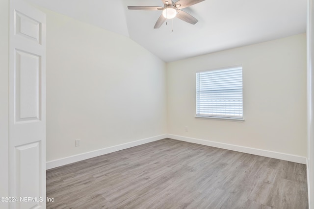 spare room with a ceiling fan, wood finished floors, lofted ceiling, and baseboards