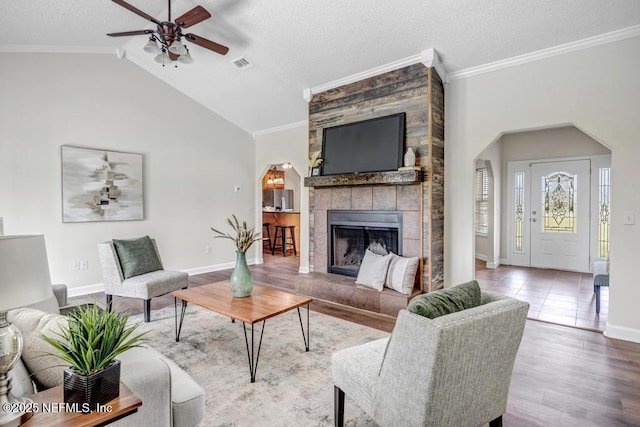 27359 Geiger Rd, Hilliard, FL 32046 - living area with a ceiling fan, a tiled fireplace, ornamental molding, baseboards, and wood finished floors