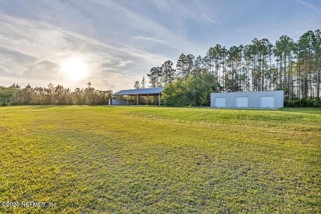27359 Geiger Rd, Hilliard, FL 32046 - view of green lawn featuring an outdoor structure, a detached garage, and a carport