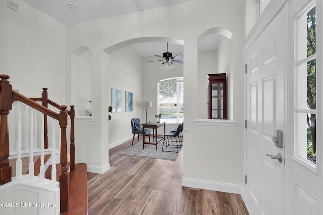767 Mosswood Chase St, Orange Park, FL 32065 - foyer entrance featuring arched walkways, wood finished floors, baseboards, a ceiling fan, and stairs