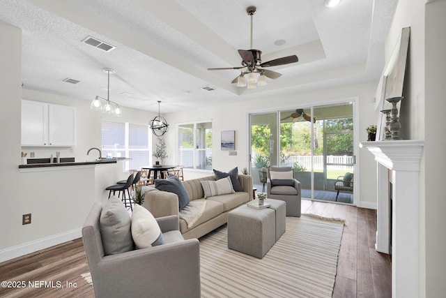 767 Mosswood Chase St, Orange Park, FL 32065 - living area featuring wood finished floors, baseboards, a ceiling fan, a fireplace, and a textured ceiling