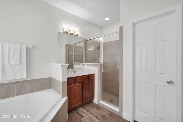 767 Mosswood Chase St, Orange Park, FL 32065 - bathroom with a shower stall, a garden tub, vanity, wood finished floors, and a textured ceiling