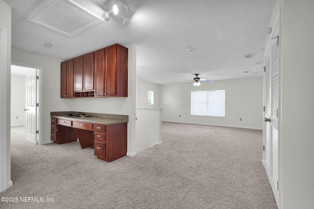 767 Mosswood Chase St, Orange Park, FL 32065 - kitchen with light carpet, a ceiling fan, baseboards, a desk, and a textured ceiling