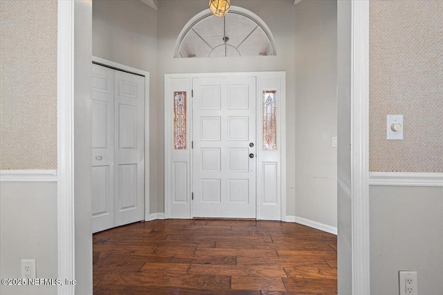 foyer entrance featuring dark wood finished floors and baseboards