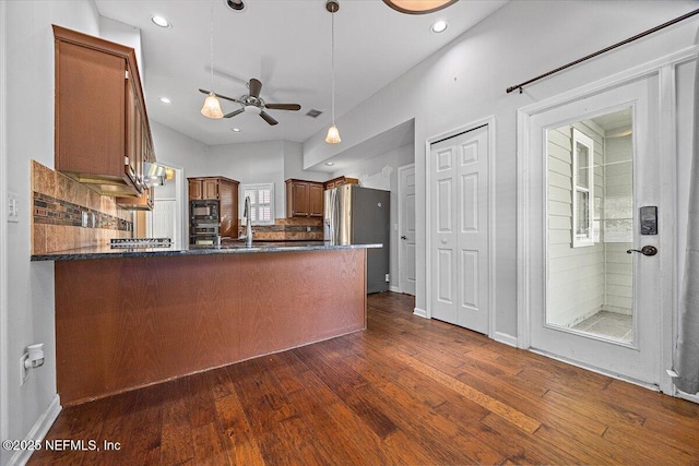kitchen with stainless steel appliances, a peninsula, dark wood-style flooring, a ceiling fan, and recessed lighting