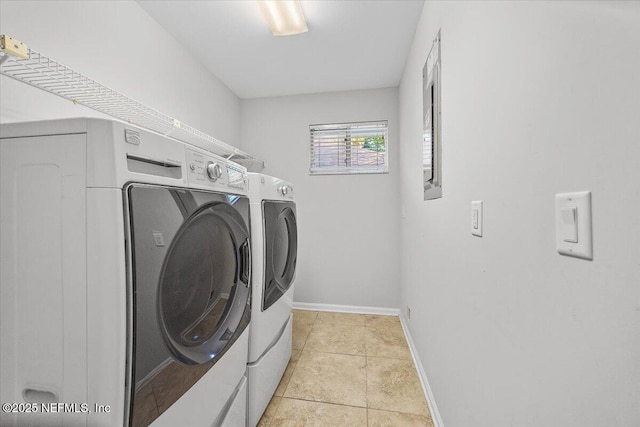 laundry area featuring separate washer and dryer, baseboards, and light tile patterned floors