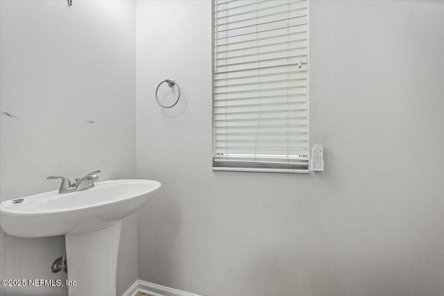 bathroom with a sink and baseboards