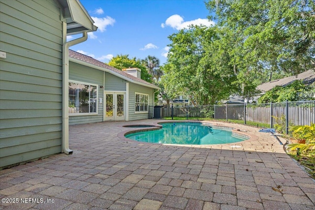 view of pool featuring french doors, a patio, and a fenced backyard