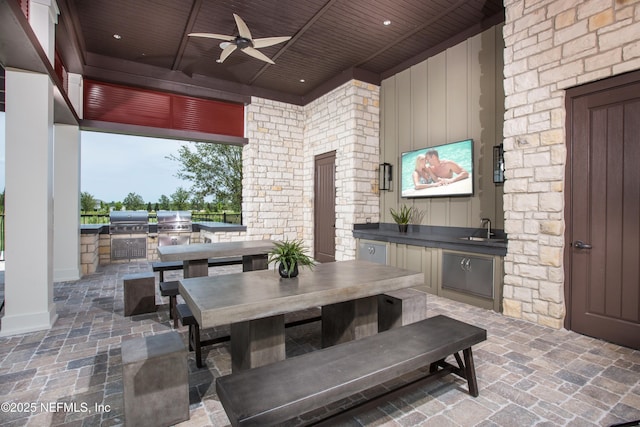 view of patio featuring area for grilling, outdoor dining space, a grill, ceiling fan, and a sink