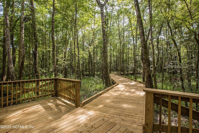 wooden terrace featuring a view of trees