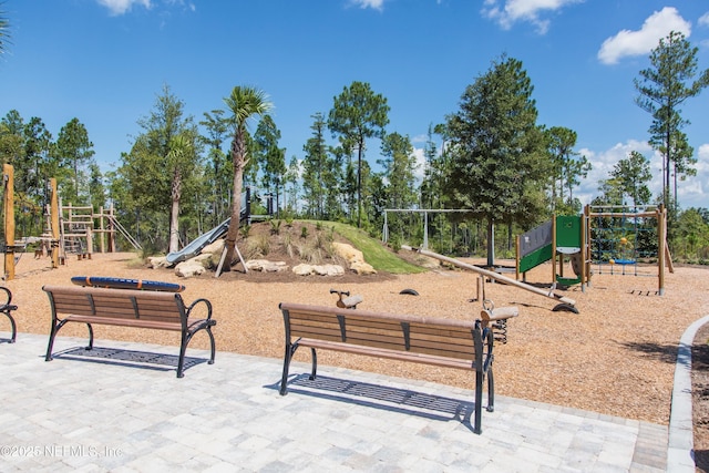 community jungle gym with view of wooded area