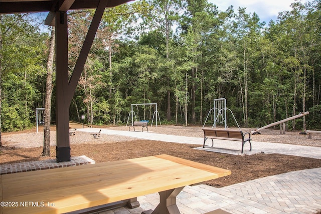 view of jungle gym featuring a forest view