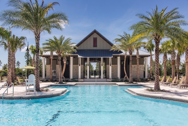 community pool with a patio and an outdoor structure