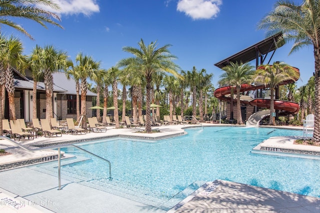 community pool featuring a water slide and a patio